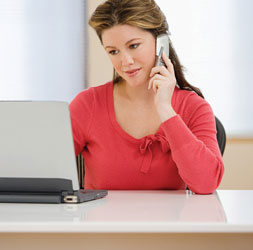 Frau mit Kontaktlinsen an PC und Handy